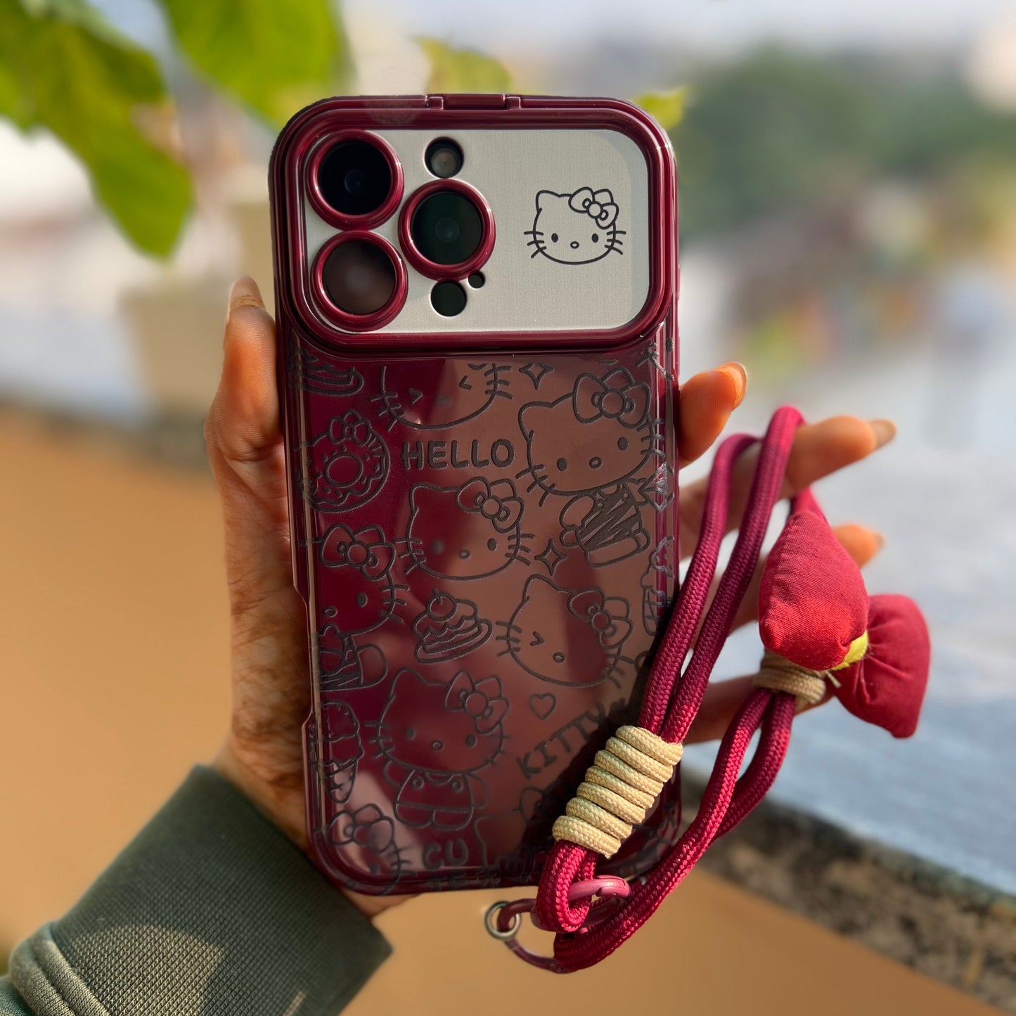 Maroon iPhone case with cute cartoon character and adjustable hand strap