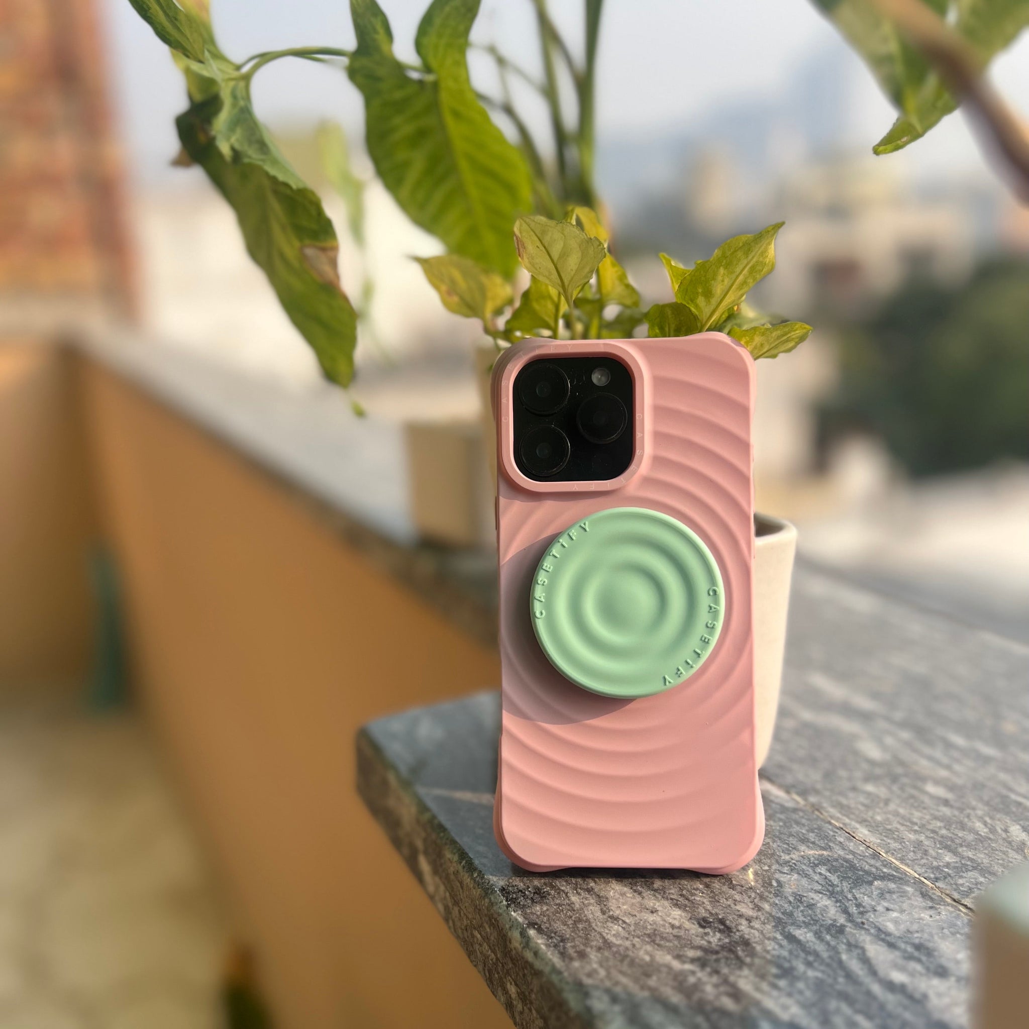 Pink silicone iPhone case with mint green pop socket grip holder