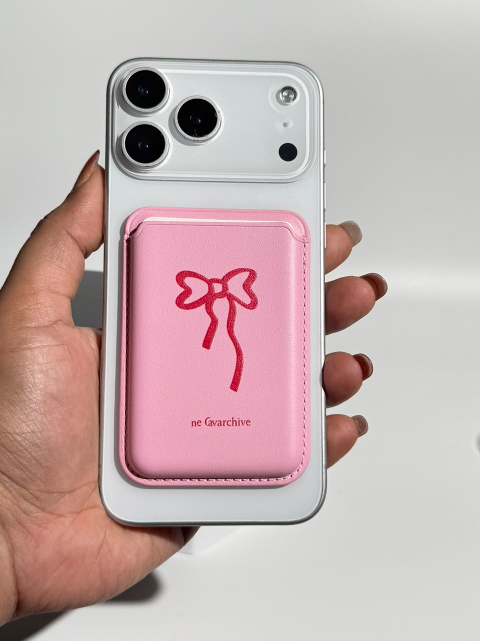 Pink bow MagSafe wallet on iPhone, front view