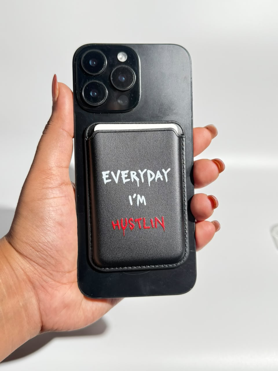 Black Everyday I'm Hustlin MagSafe wallet on iPhone